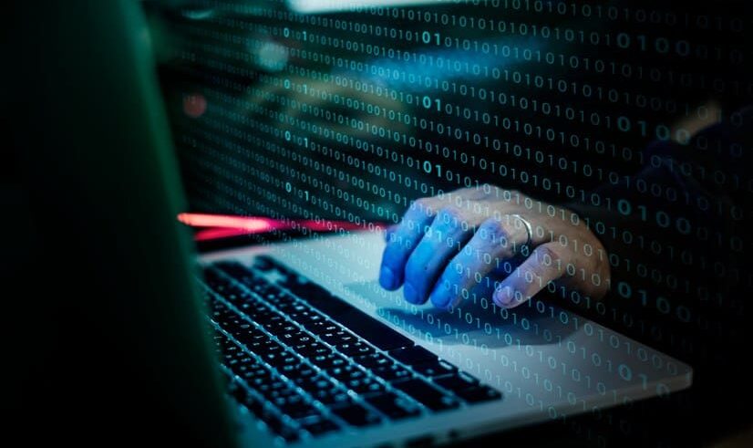 Imagem mãos sobre o computador simulando um ataque cibernético